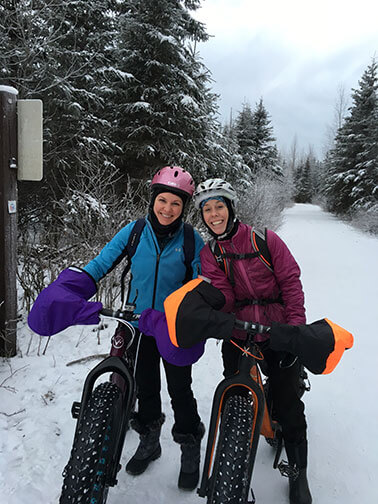 CRNAs Sarah and Kelly in snow on bikes