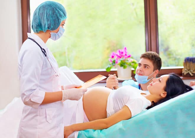 doctor consulting happy parents on childbirth
